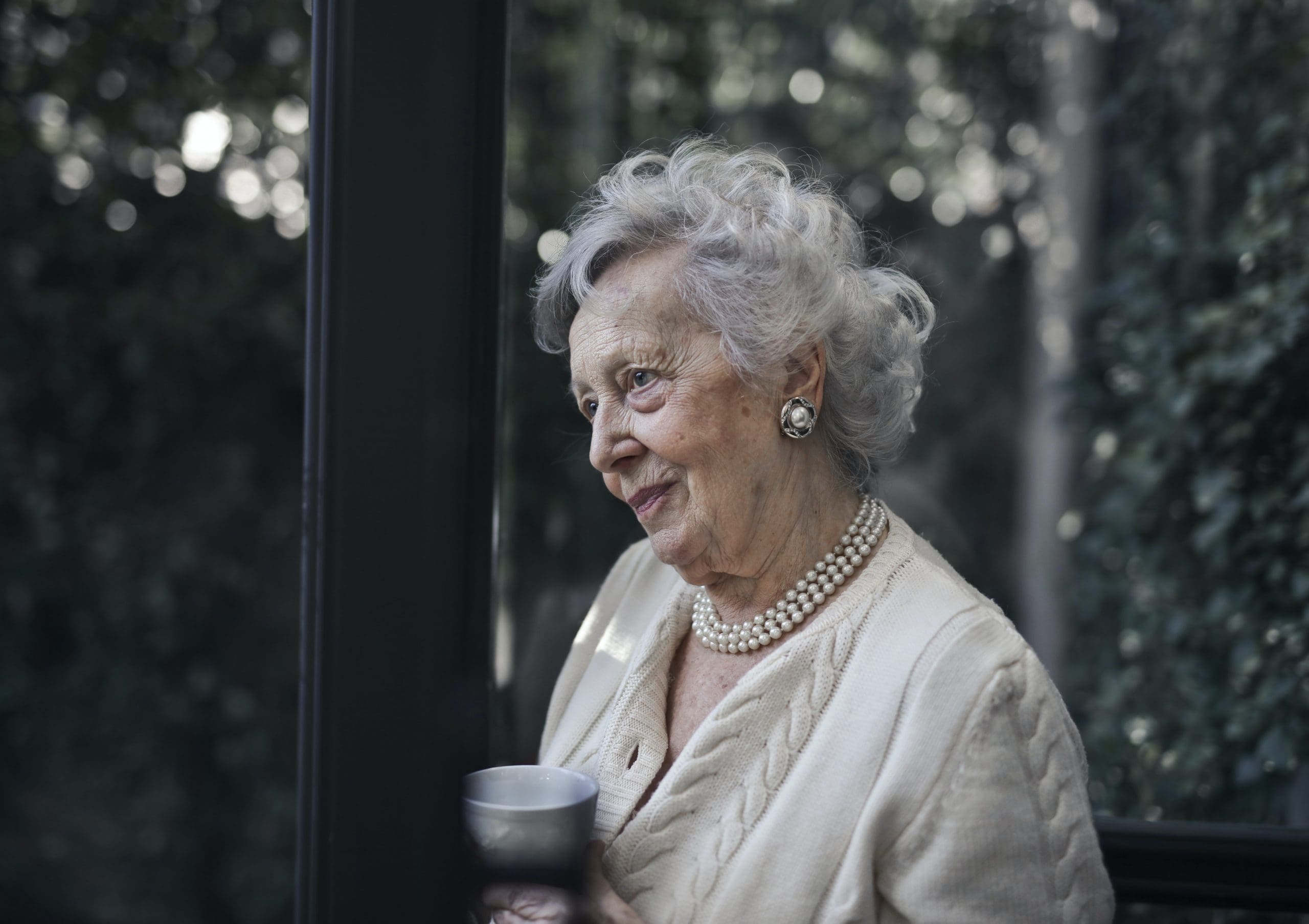 Grandmother looking out of garden window