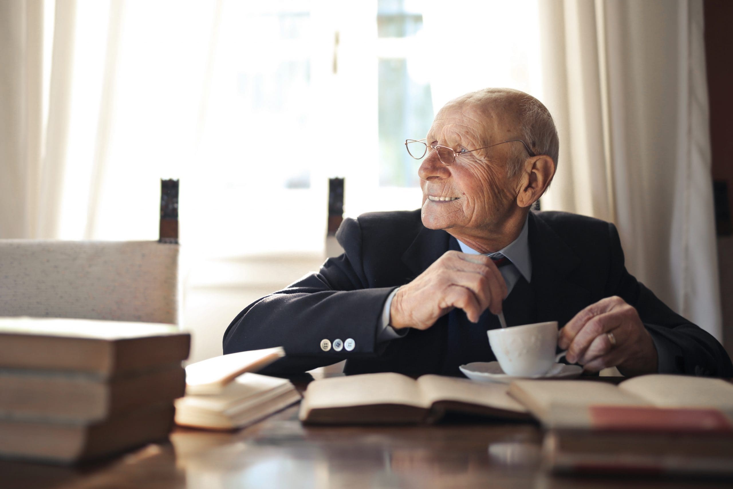 older man stirring a cup of tea