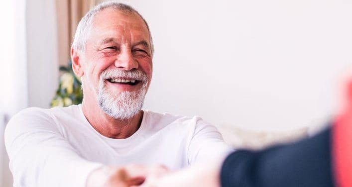 Elderly man being helped to stretch