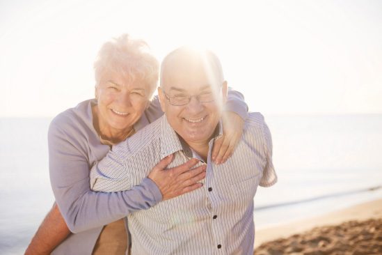 Elderly-couple-smiling-in-the-sunshine