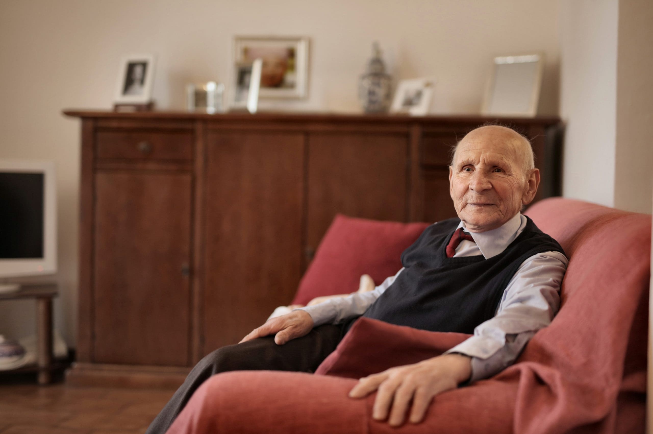 Older man sat in armchair at home