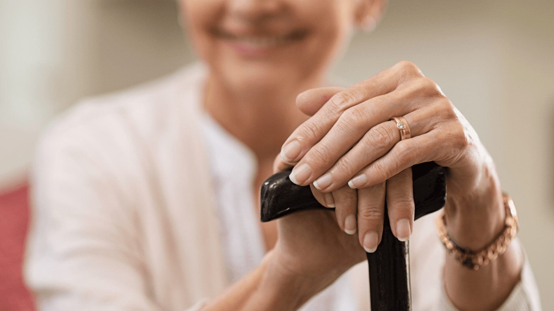 Older hands resting on a cane