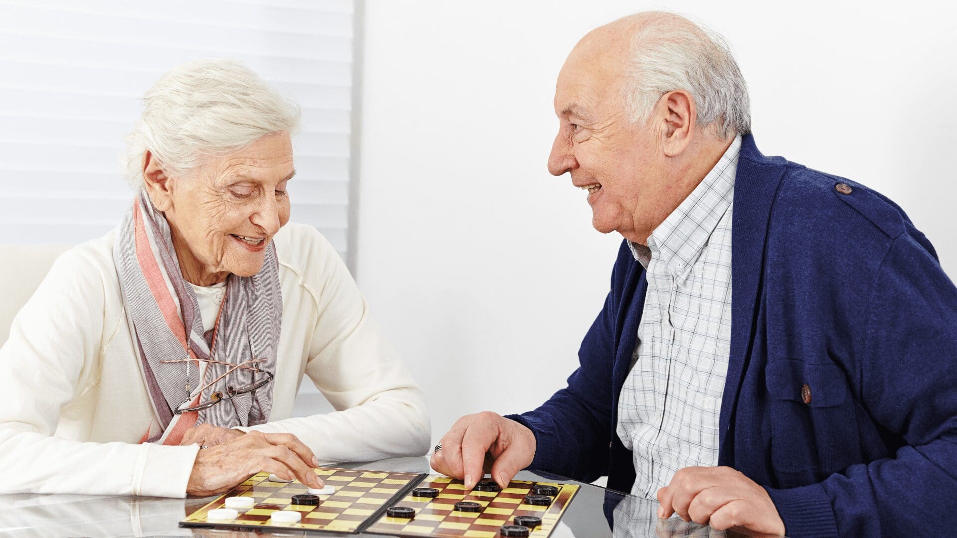 elderly couple playing checkers