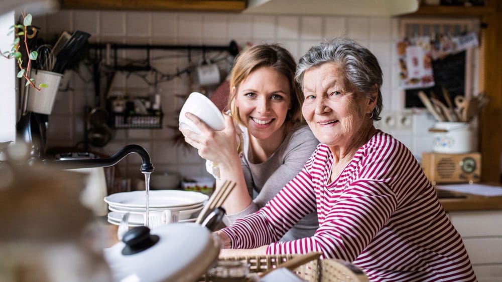 elderly lady washing-up-with granddaughter