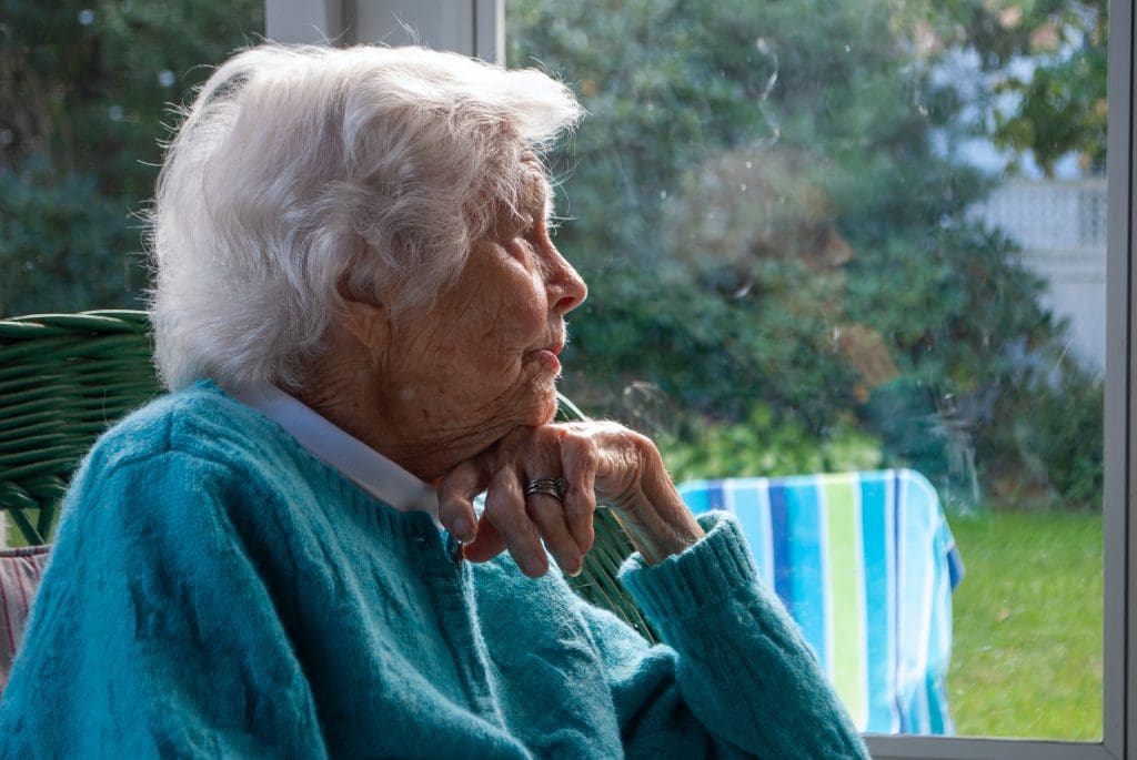 older lady at home  looking out onto a garden